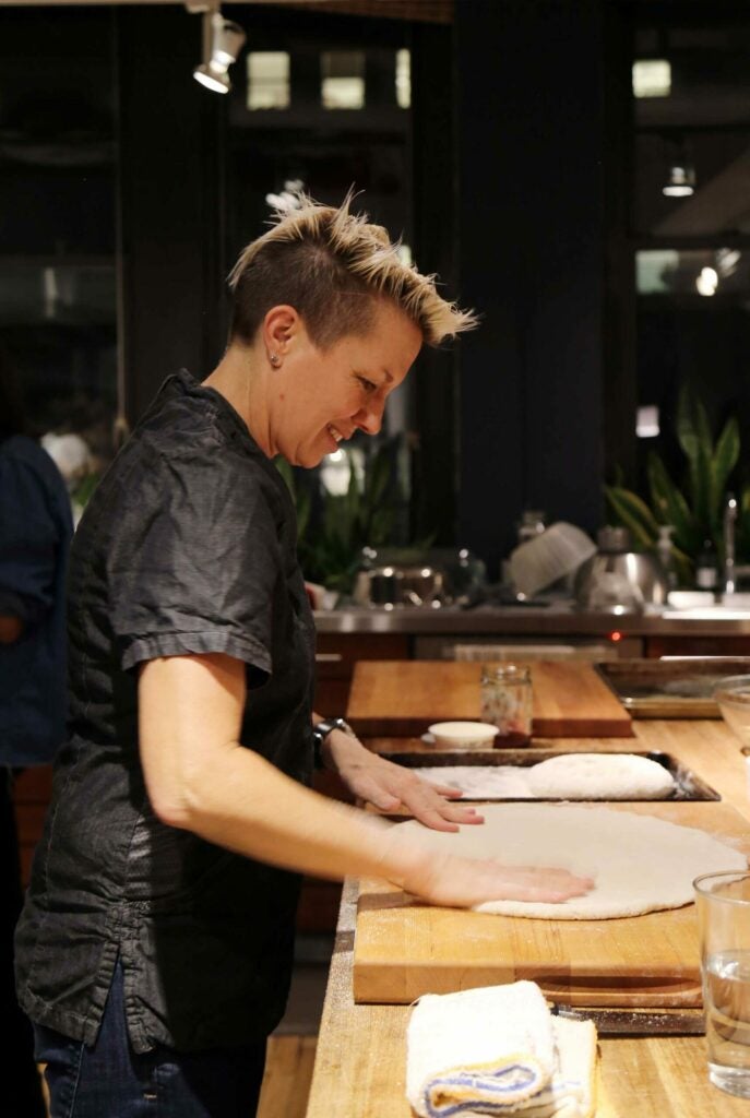 female chef rolling dough