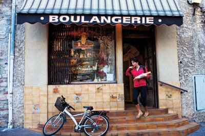 A woman pauses for her daily bread at Boulangerie La Belle Epoque in Antibes.