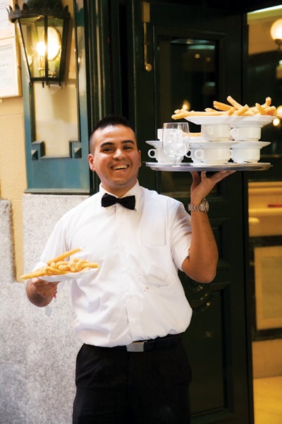 A server in Madrid, Spain, carries hot chocolate and churros