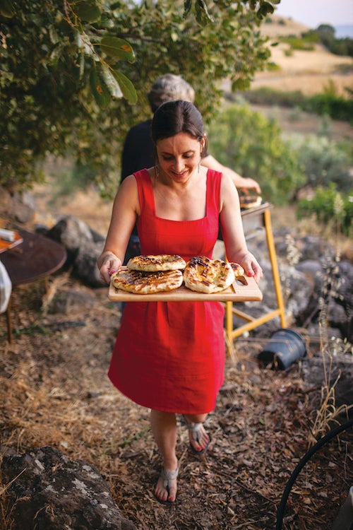 Lisa Fisher carries a tray of grilled pita