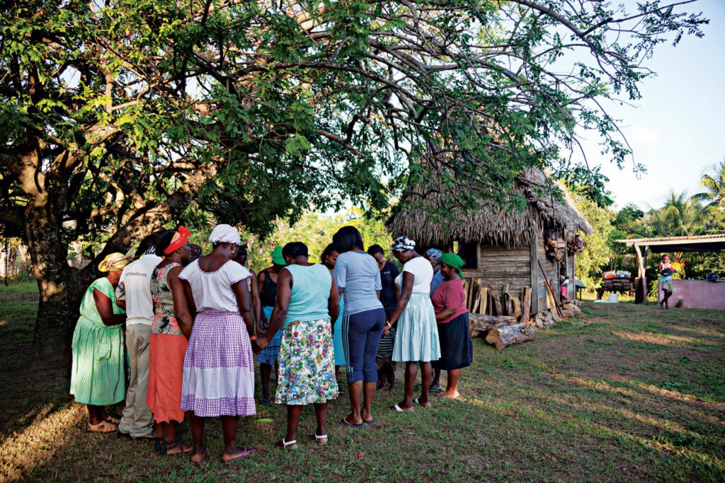 Members of a cassava bread producing cooperative share a prayer in Ciriboya, Honduras