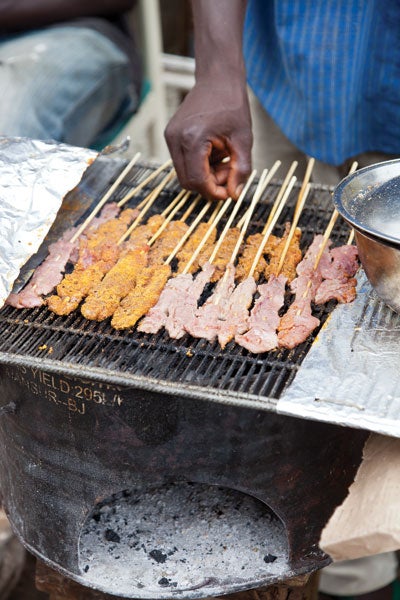 A street vendor grills kabobs