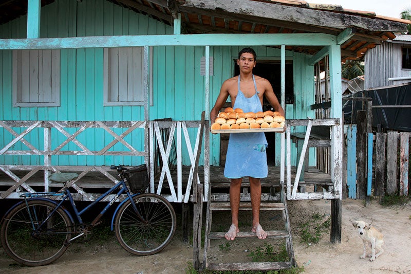 Luciano Lima holds a tray of just-baked rolls at a bakery in the village of Pesqueiro, near Soure.