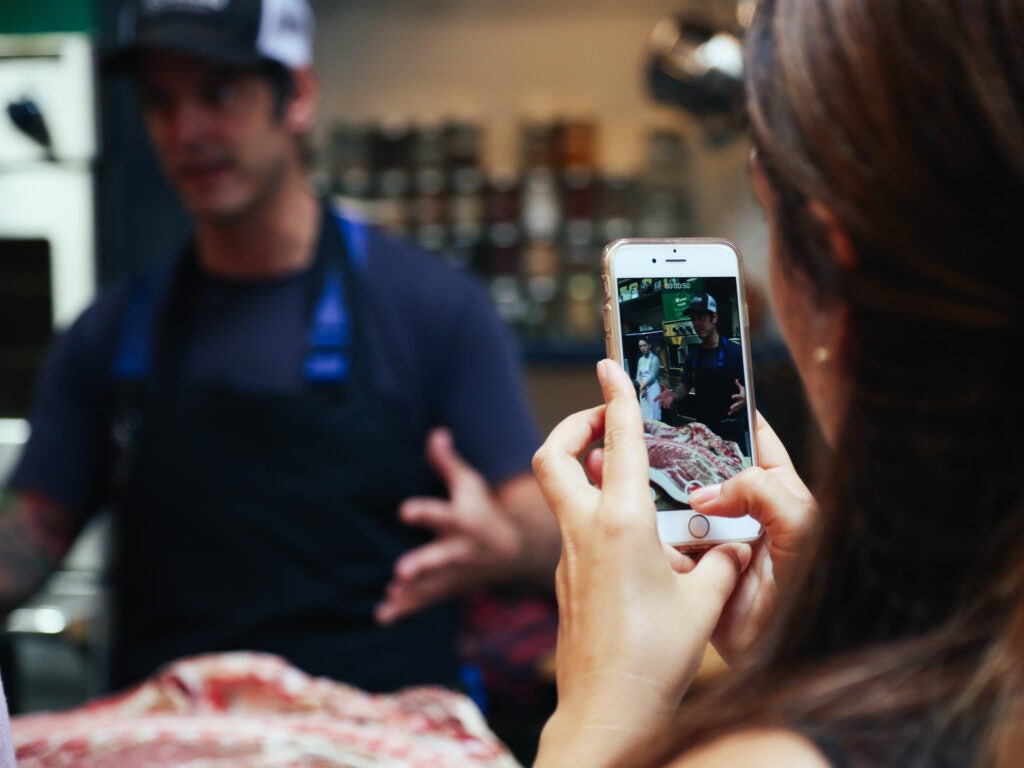 A blogger takes a photo during the Fleisher's butcher demonstration on Tuesday.