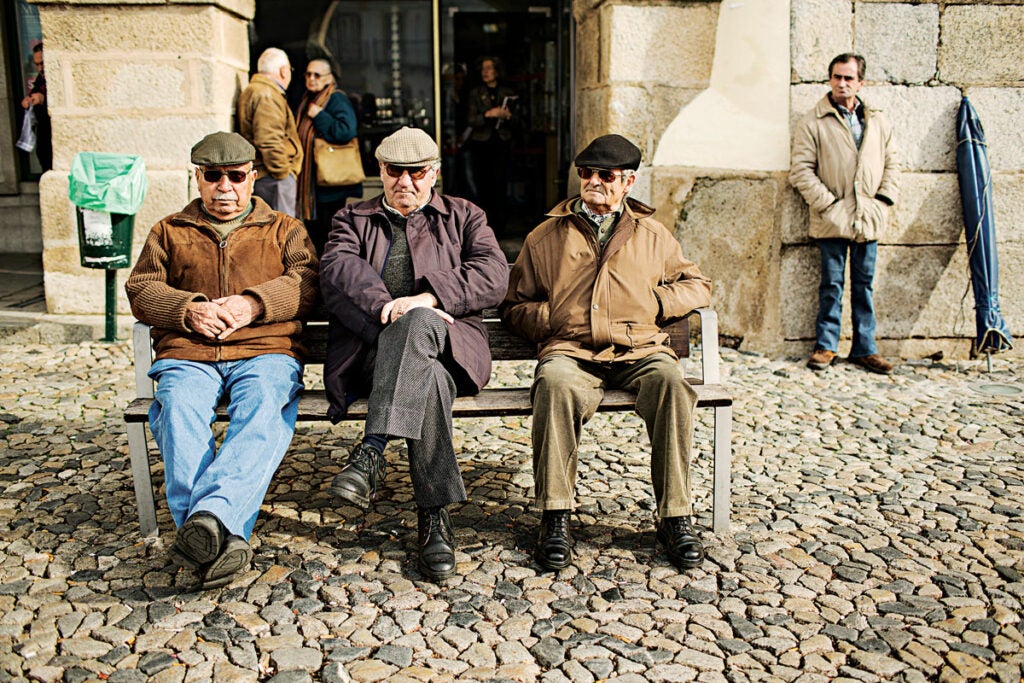 group of older men sitting on a bench