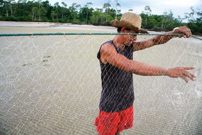 a fisherman checks his nets in the village of Pesqueiro