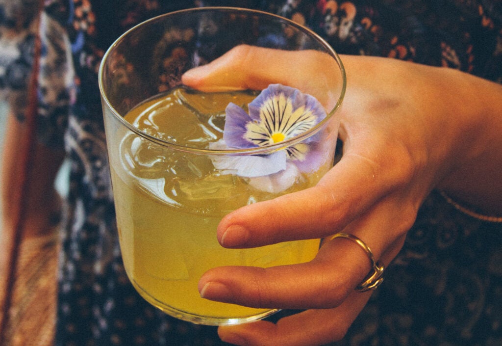 This flower-garnished Smoke on the Water cocktail is made with Gewürztraminer, mezcal, and passion fruit.