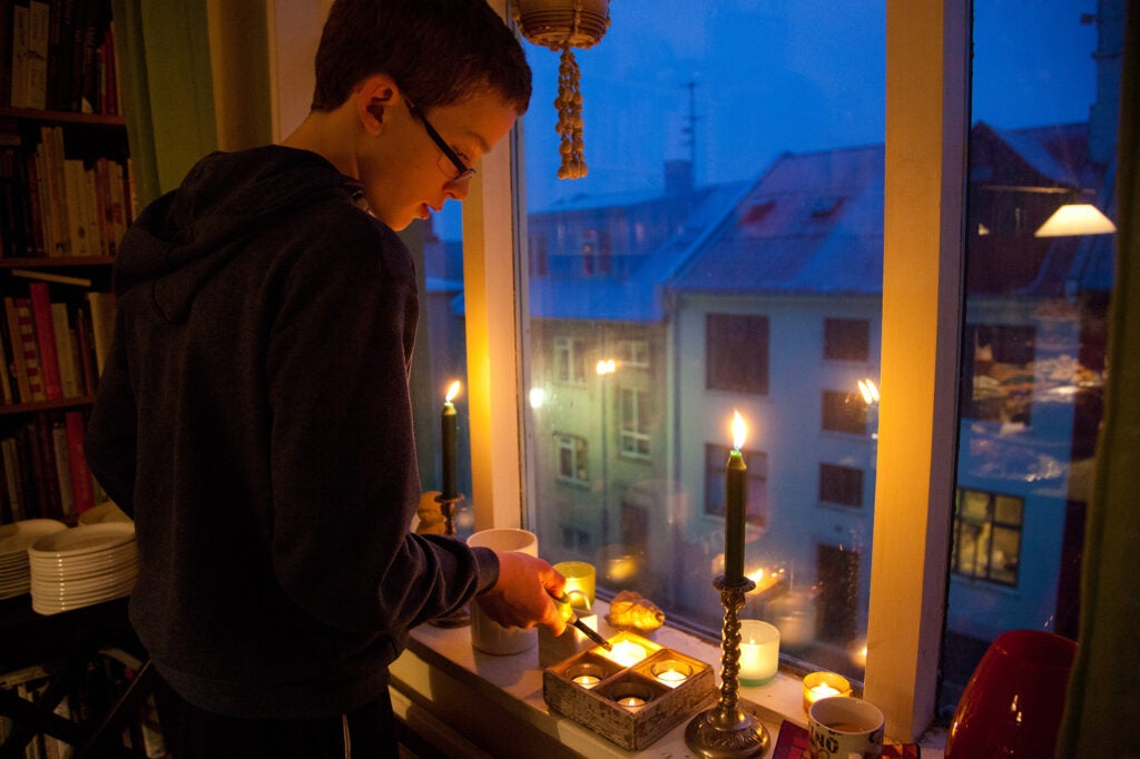 A boy lights candles in Iceland