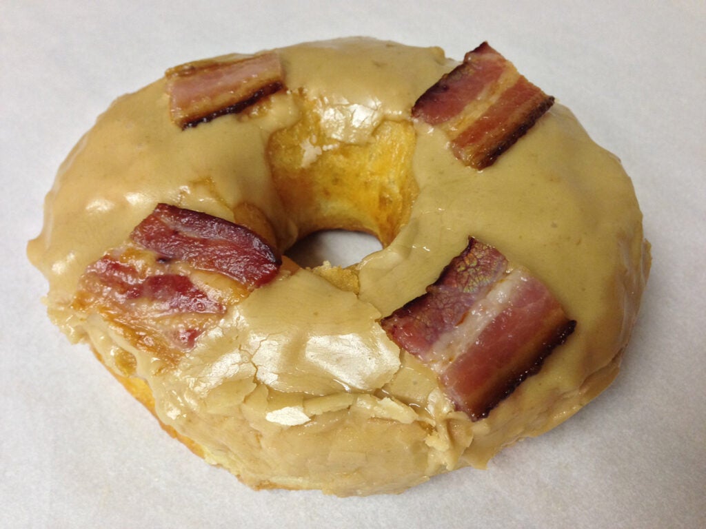 Maple bacon donut on white background.