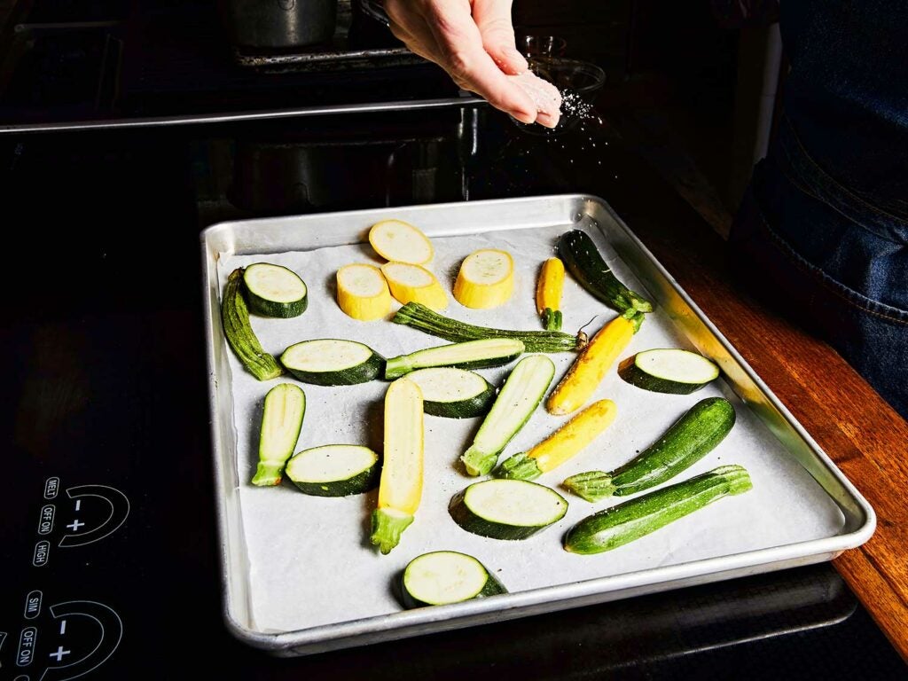 Summer squash cut into chunks on pan in oven.