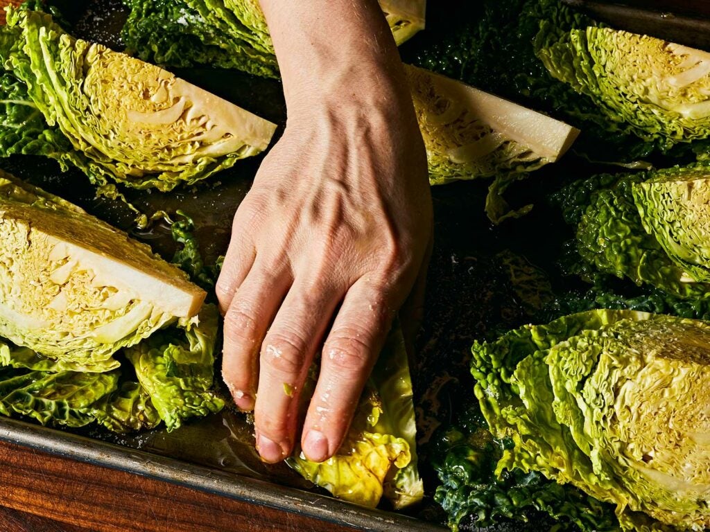 Massaging cabbage with olive oil.