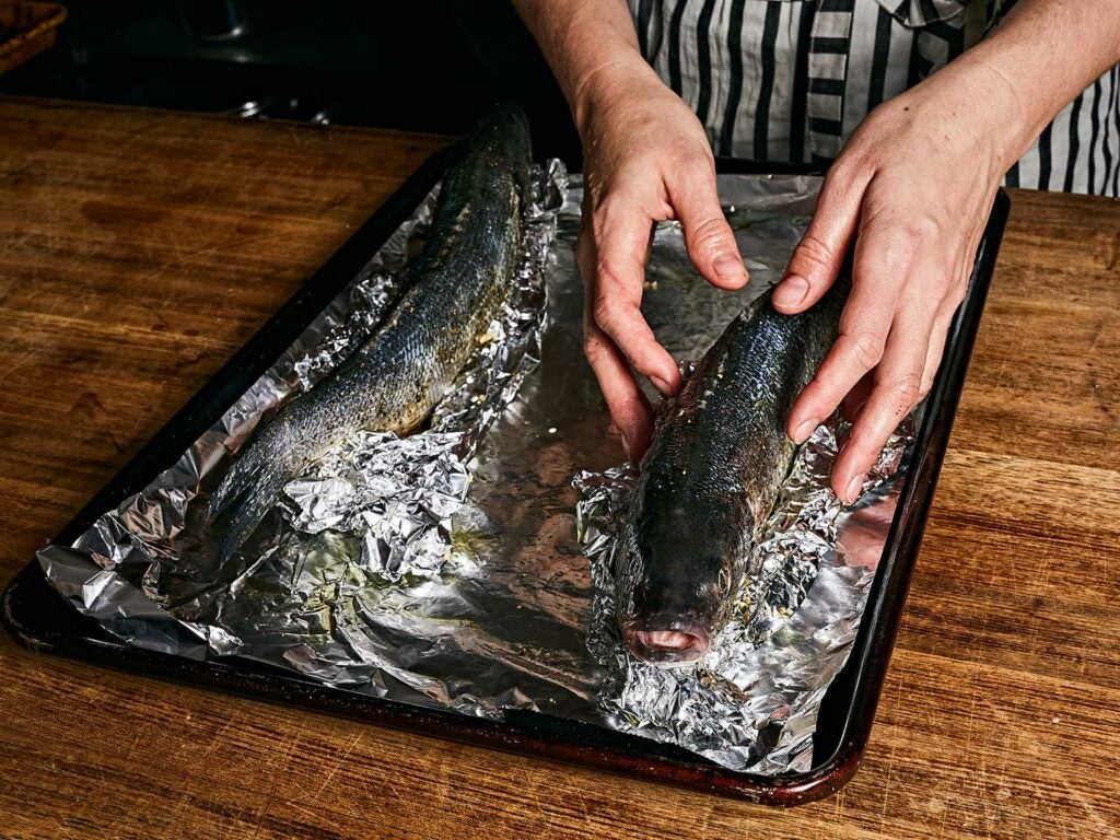 Propping the fish upright and covering in aluminum foil.