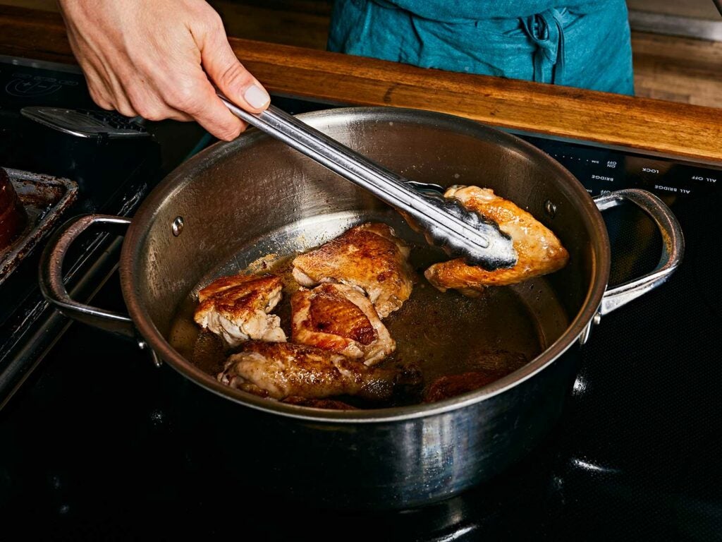 Cooking chicken in large pot.