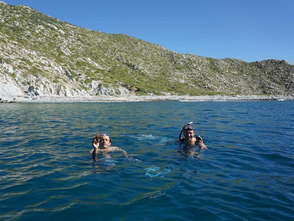 Diving for chocolate clams along East Cape with chef Gomez (right).