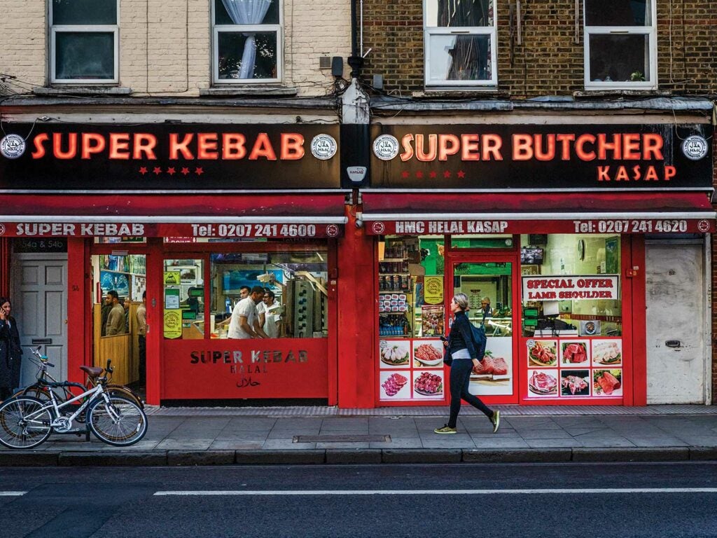 A woman walks by a kebab shop in London.