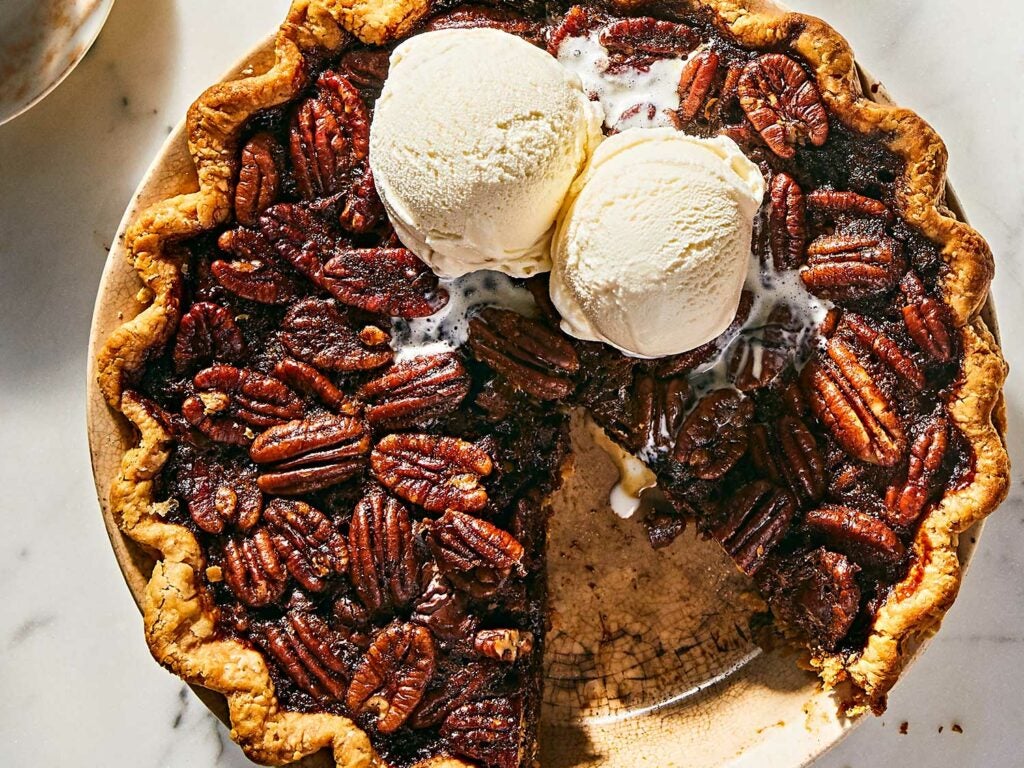 Scoops of vanilla ice cream on top of bourbon chocolate pecan pie.