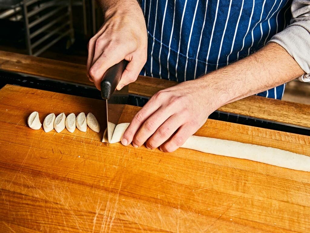 Cutting dough into bite-sized pieces for dumplings.