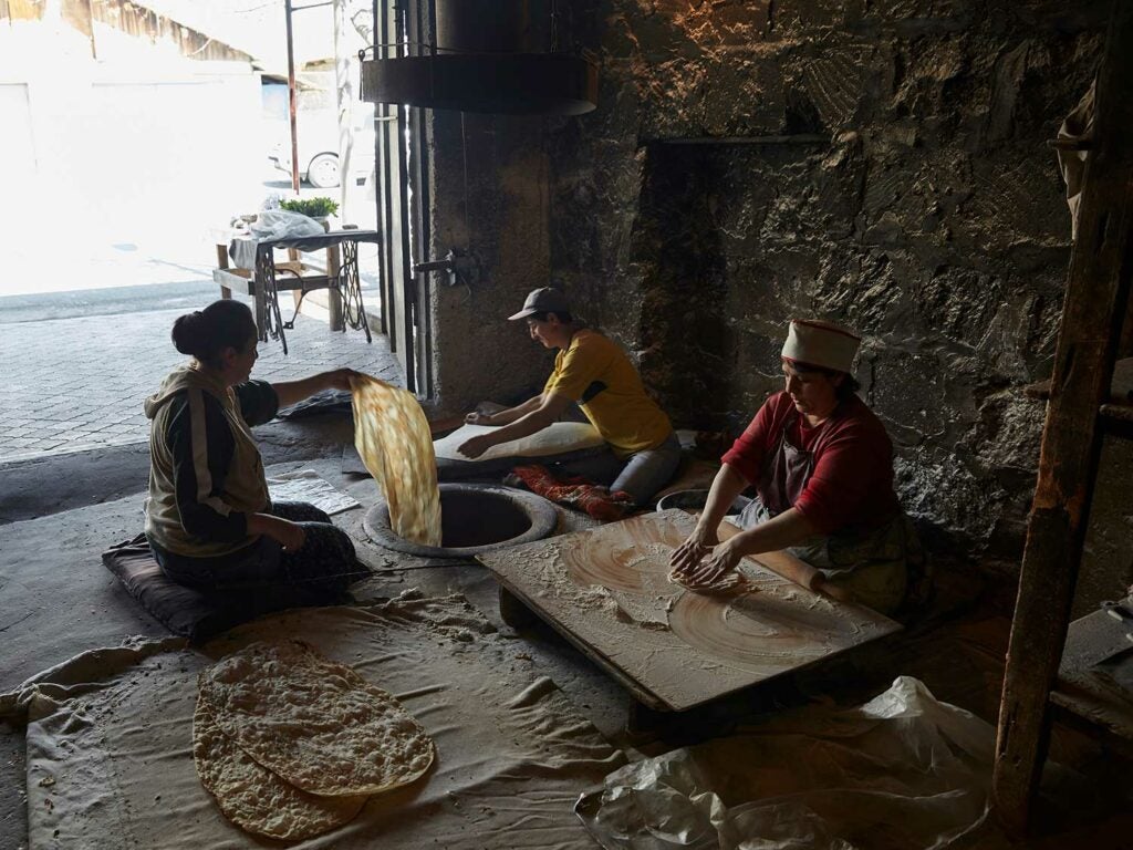 Busy at working making lavash, a traditional Armenian flatbread cooked that’s cooked on the walls of a clay oven called a tonir.