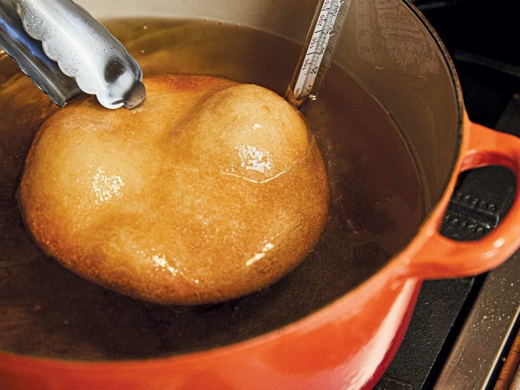 Frying discs of dough in frying pan.